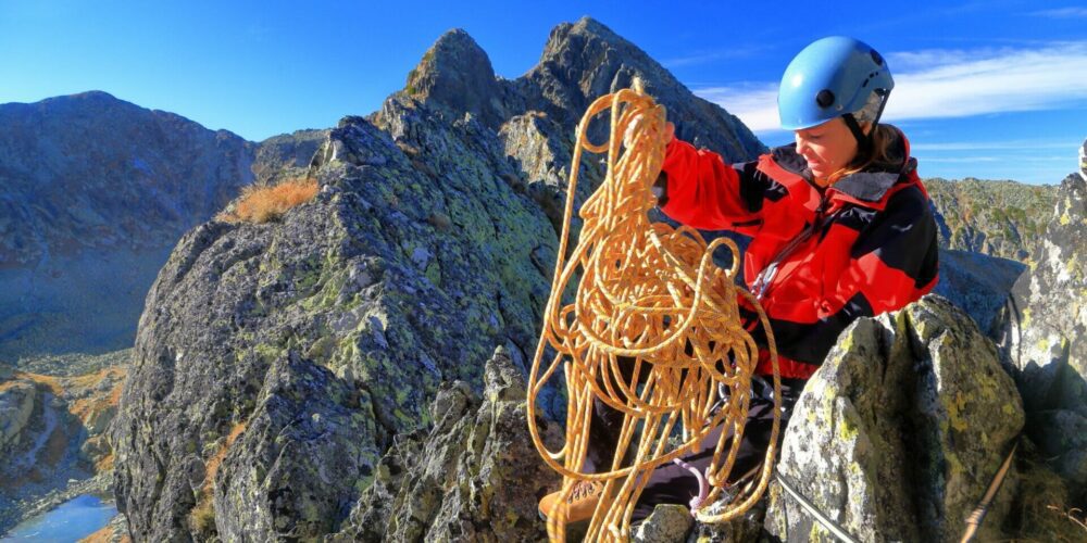 Vasthouden juist als het spannend wordt persoon die touw bewerkt tijdens het beklimmen van een berg